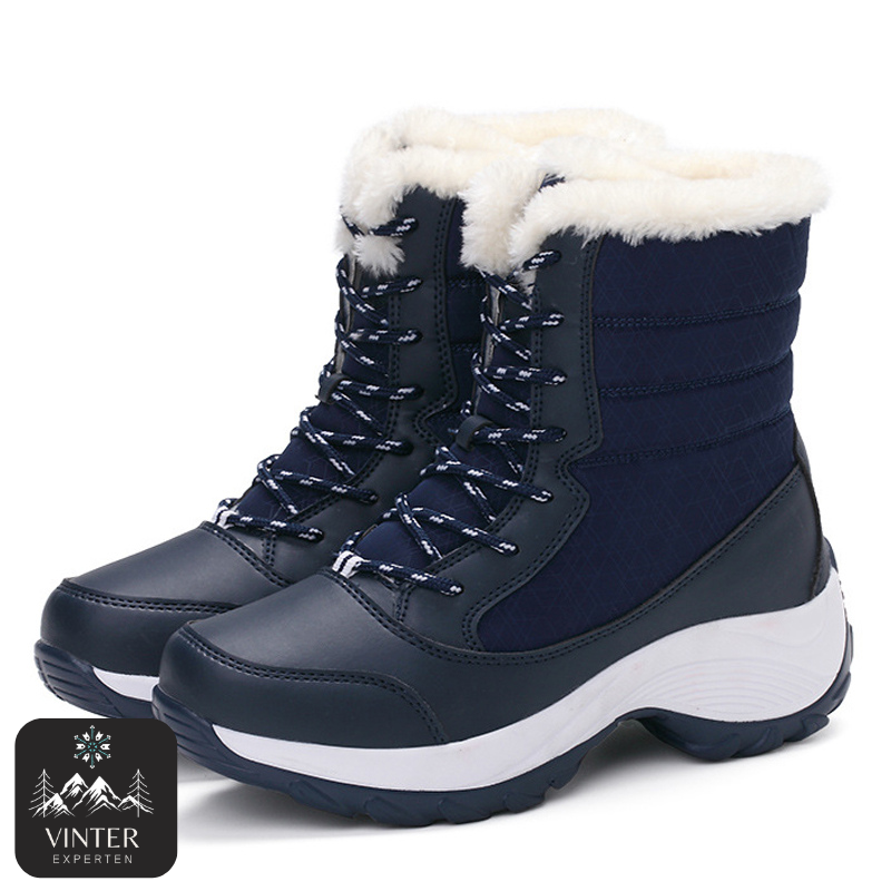Blåa vinterkängor för dam från Vinterexperten, med vit värmande fuskpäls, snörning och robust halkfri sula för komfort och stabilitet under kalla vinterdagar.