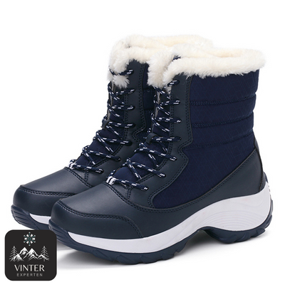 Blåa vinterkängor för dam från Vinterexperten, med vit värmande fuskpäls, snörning och robust halkfri sula för komfort och stabilitet under kalla vinterdagar.