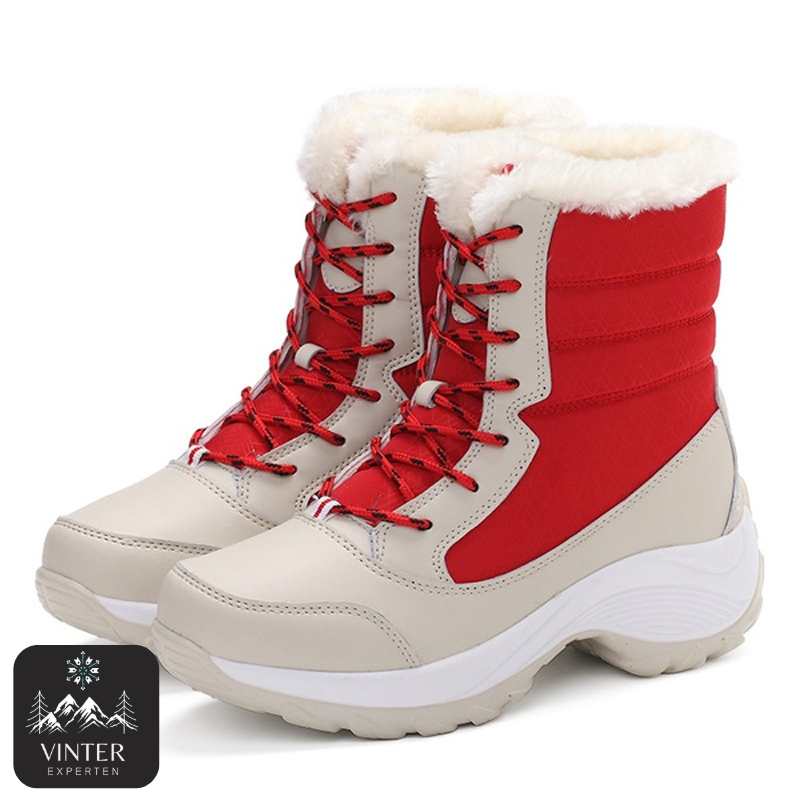 Röda vinterkängor för dam från Vinterexperten, med vit värmande fuskpäls, snörning och robust halkfri sula för komfort och stabilitet under kalla vinterdagar.