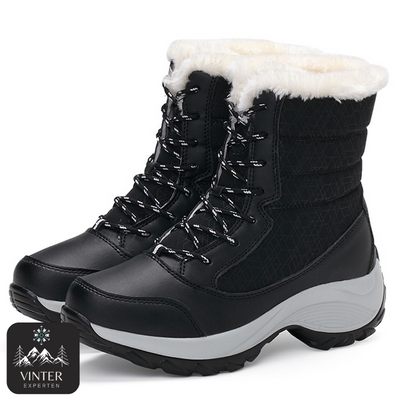 Svarta vinterkängor för dam från Vinterexperten, med vit värmande fuskpäls, snörning och robust halkfri sula för komfort och stabilitet under kalla vinterdagar.