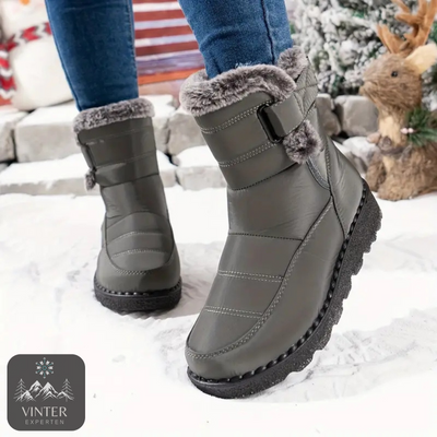 Gråa fodrade vinterskor för dam från Vinterexperten, med värmande fuskpäls och halkfri sula. Perfekta för vinterpromenader och kalla dagar i snö.